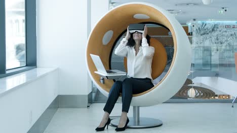 Businesswoman-in-vr-headset-using-laptop